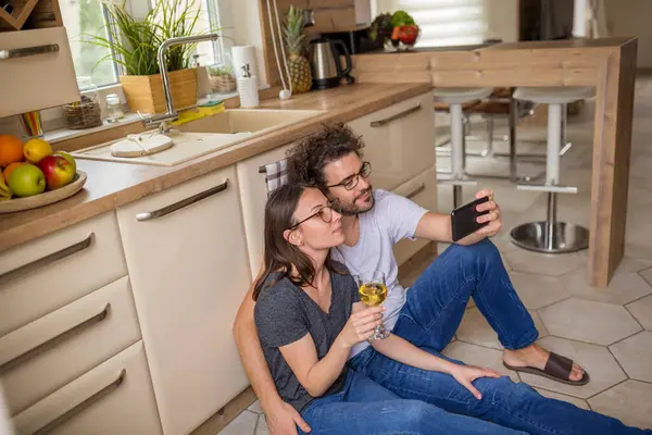 Güzel Birbirine Aşık Genç Bir Çift Mutfakta Oturmuş Akıllı Telefon — Stok fotoğraf