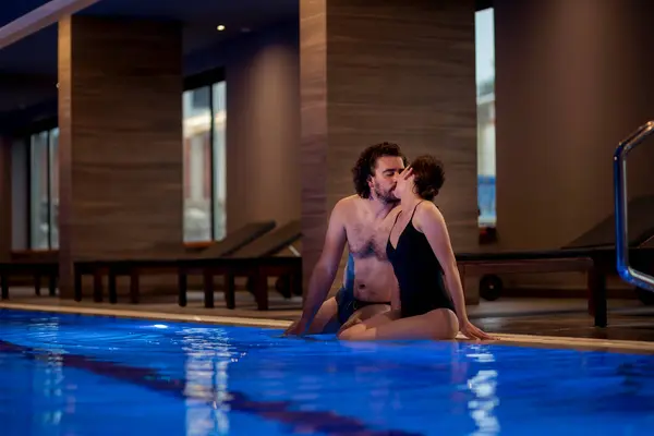 愛する美しい若いカップルは 休暇を楽しんで スパセンタースイミングプールでリラックス 抱擁し — ストック写真