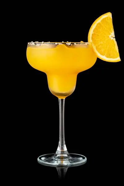 オレンジマルガリータカクテル テキーラ トリプルセクション オレンジジュース 粉砕された氷とガラスの縁にいくつかの塩 黒い背景に隔離されたオレンジのスライスで装飾 — ストック写真