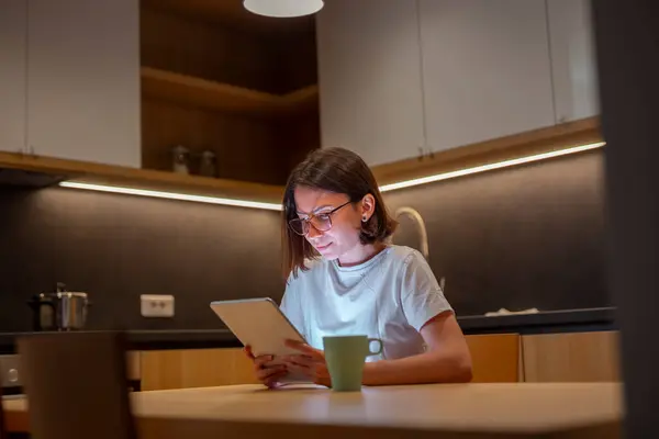 Mladá Žena Pyžamu Sedí Kuchyňského Stolu Čte Ebook Pomocí Tabletu — Stock fotografie