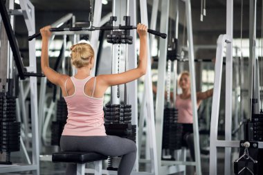 Güçlü genç bir kadın spor salonunda spor yaparken, spor salonunda spor yapıyor.