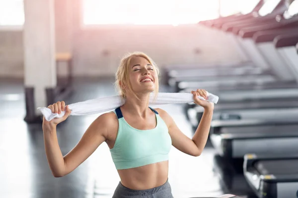 Szczęśliwa kobieta pobyt z ręcznikiem po treningu w siłowni, a. — Zdjęcie stockowe