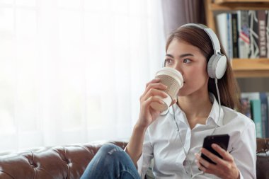 Genç Asyalı kadın kulaklık ve h ile müzik dinleme keyfini çıkarın