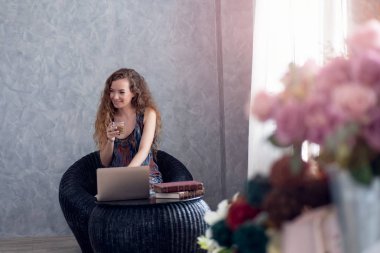 Genç iş kadını masada dizüstü bilgisayar ile kahve içme