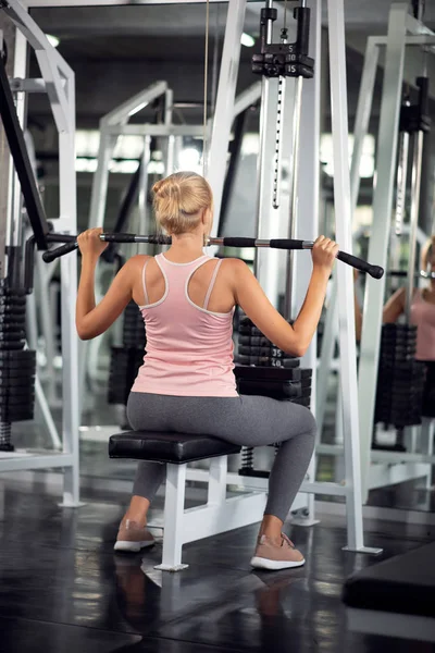 Güçlü kadın ile açılan makine bir fitness kulübünde egzersiz,