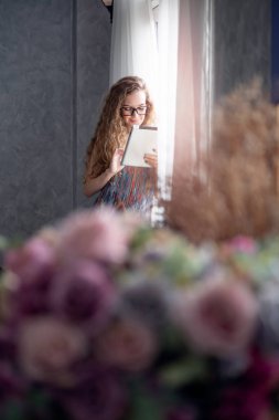 Evde dijital tablet bilgisayarda çalışan genç kadın 