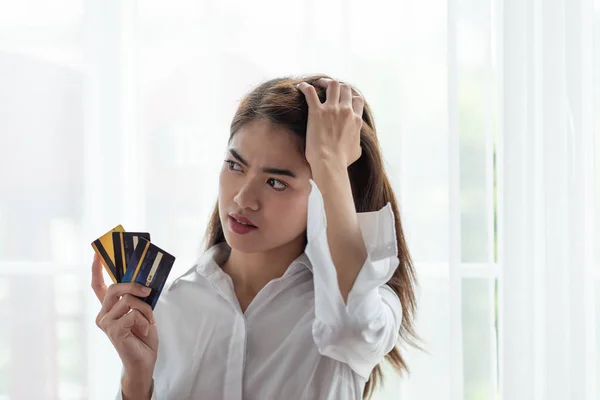 Joven mujer asiática sosteniendo tarjeta de crédito con sensación de estrés —  Fotos de Stock