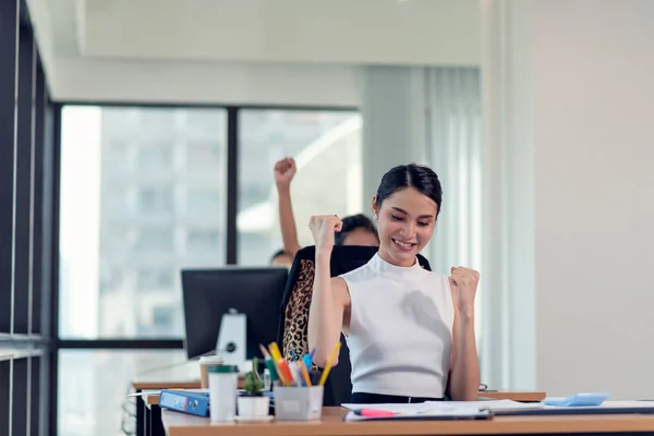 Счастливая деловая женщина, работающая в офисе с поднятыми руками — стоковое фото