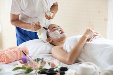 Spa güzellik salonunda yüz maskeli güzel Asyalı kadın, keyfini çıkarın