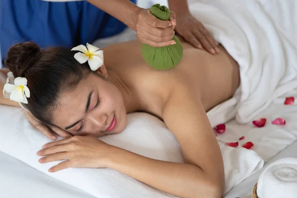 Mooie Aziatische vrouw krijgt massage met Thaise kruiden ballen in — Stockfoto