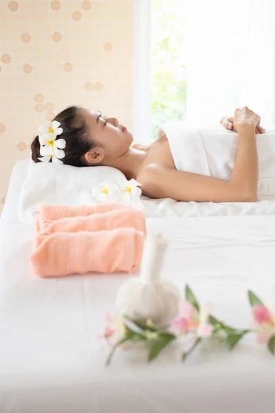 Krásná asijská žena ležící na masážní posteli relaxační v lázních — Stock fotografie