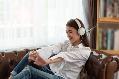 Genç Asyalı kadın kulaklık, happ ile müzik dinleme keyfini çıkarın
