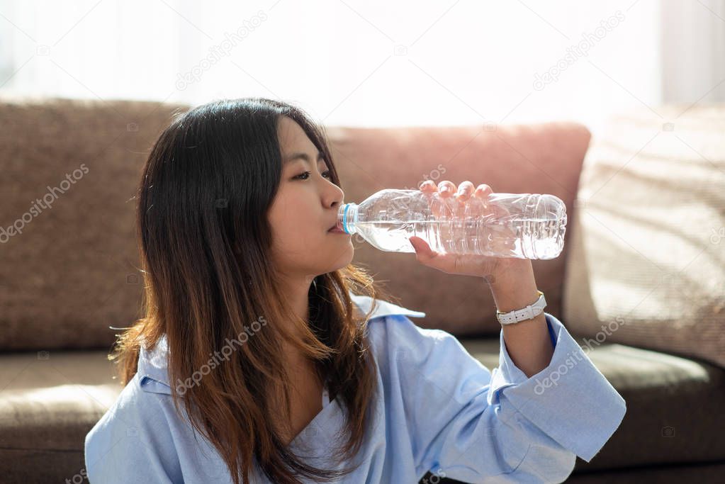 Young Asian woman drinking water from bottle