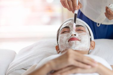 Spa güzellik salonunda yüz maskeli güzel Asyalı kadın, keyfini çıkarın