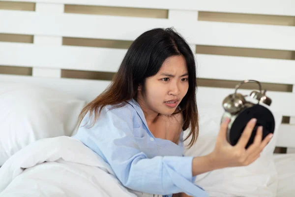 Young Asian woman shocked as she waking up late in morning, youn