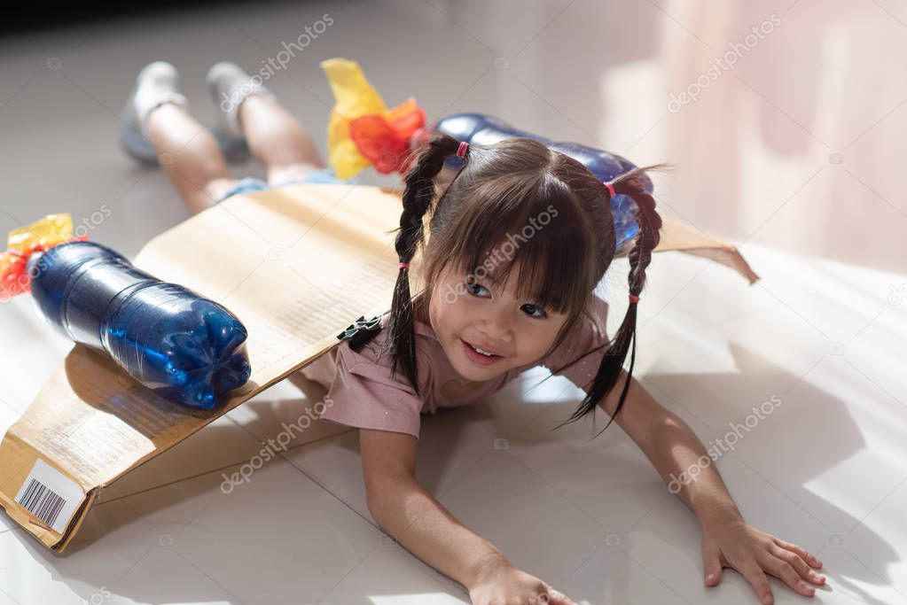 Happy Asian little child girl playing in an astronaut costume