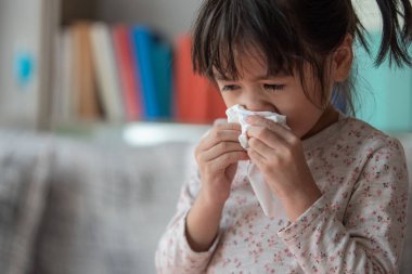 Hasta Asyalı kız burnu mendil kağıdına, sağlık hizmetlerine ve tıbbi konsepte sümkürdü.