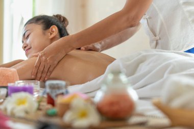 Genç Asyalı kadın spa salonunda masaj yaptırıyor, keyif alıyor ve rahatlatıyor, sağlıklı bir konsept.