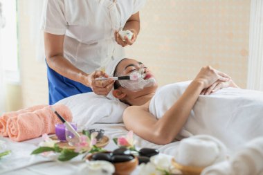 Güzellik salonunda maske takmış genç Asyalı kadın, eğleniyor ve dinleniyor, cilt bakımı ve sağlık hizmetleri kavramı