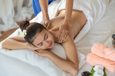 Genç Asyalı kadın spa salonunda masaj yaptırıyor, keyif alıyor ve rahatlatıyor, sağlıklı bir konsept.
