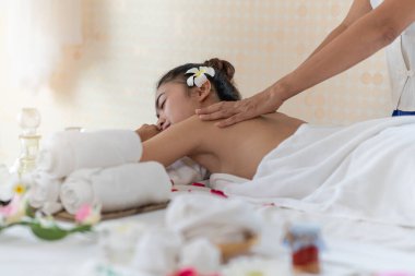 Genç Asyalı kadın spa salonunda masaj yaptırıyor, keyif alıyor ve rahatlatıyor, sağlıklı bir konsept.