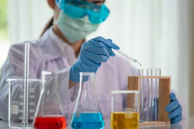 Test tüpü ile Asyalı kadın bilim adamının klinik laboratuvar, bilim ve kimya konsepti, tıp teknolojisi araştırması yapan