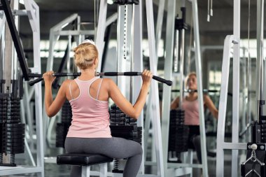 Güçlü genç bir kadın spor salonunda spor yaparken, spor salonunda spor yapıyor.