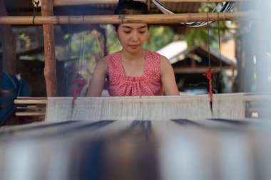 Geleneksel Tayland dokuma makinesiyle örgü ören genç Asyalı kadınlar