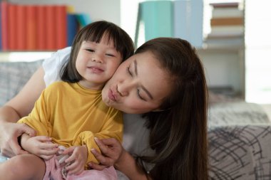Anne evde kızıyla eğleniyor ve oynuyor, mutlu Asyalı çocuk, aile kavramı