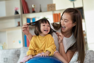 Anne evde kızıyla eğleniyor ve oynuyor, mutlu Asyalı çocuk, aile kavramı