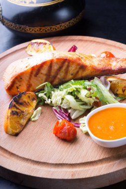 Ahşap oyun tahtası salata ile servis ızgara somon dilimi