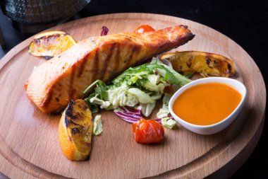 Ahşap oyun tahtası salata ile servis ızgara somon dilimi