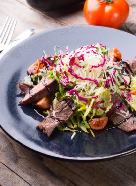 Alarmdan karanlık bir tabağa dilimlenmiş sebze salata ile servis edilir