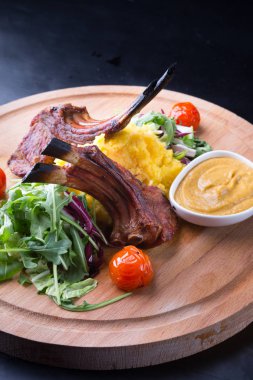 Ahşap oyun tahtası salata ile servis ızgara kuzu eti