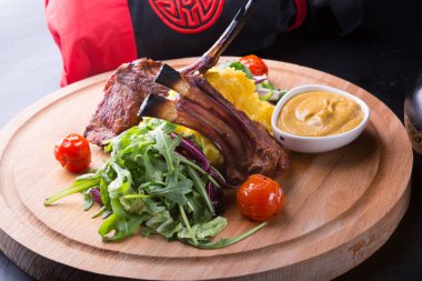 Ahşap oyun tahtası salata ile servis ızgara kuzu eti