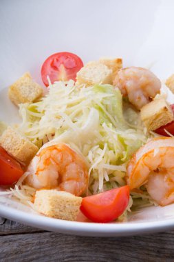 Beyaz bir kase karides ile taze Sezar salata servis
