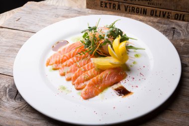 Tuzlu ve dilimlenmiş pembe taze somon roka salatası ile servis