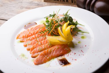 Tuzlu ve dilimlenmiş pembe taze somon roka salatası ile servis