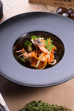 Siyah bir tabakta Asya Deniz ürünleri salatası