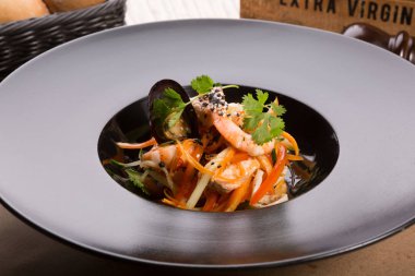 Siyah bir tabakta Asya Deniz ürünleri salatası