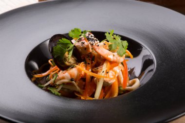 Siyah bir tabakta Asya Deniz ürünleri salatası