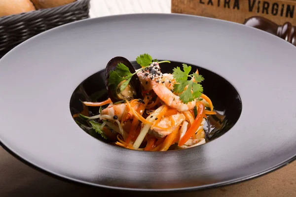 Siyah bir tabakta Asya Deniz ürünleri salatası