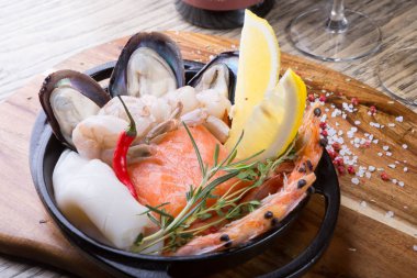 Şişe şarapla ahşap tahta üzerinde deniz ürünleri aperatifler servis