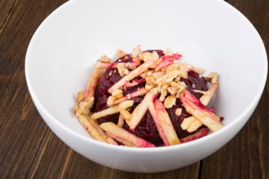 Beyaz bir kase içinde elma ile servis sağlıklı organik pancar salatası