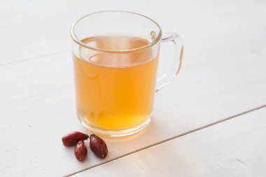 Cam Kupa ahşap bir masa üzerinde sarı bitkisel çay