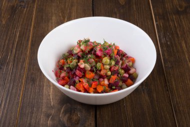 Beyaz bir kase içinde karışık taze pancar salatası hizmet