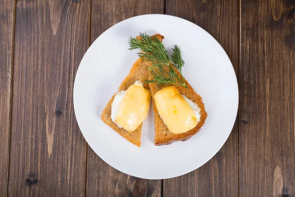 Fried toasts with baked egg and cheese on it