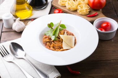 Ahşap masa öğle yemeği için et ve peynir ile tagliatelle makarna servis