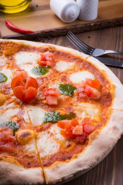 İki farklı pizza taze pişmiş ve ahşap masaya servis