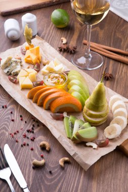 Meyve tabağı aperatifler için beyaz şarap dolu ahşap bir masaya servis